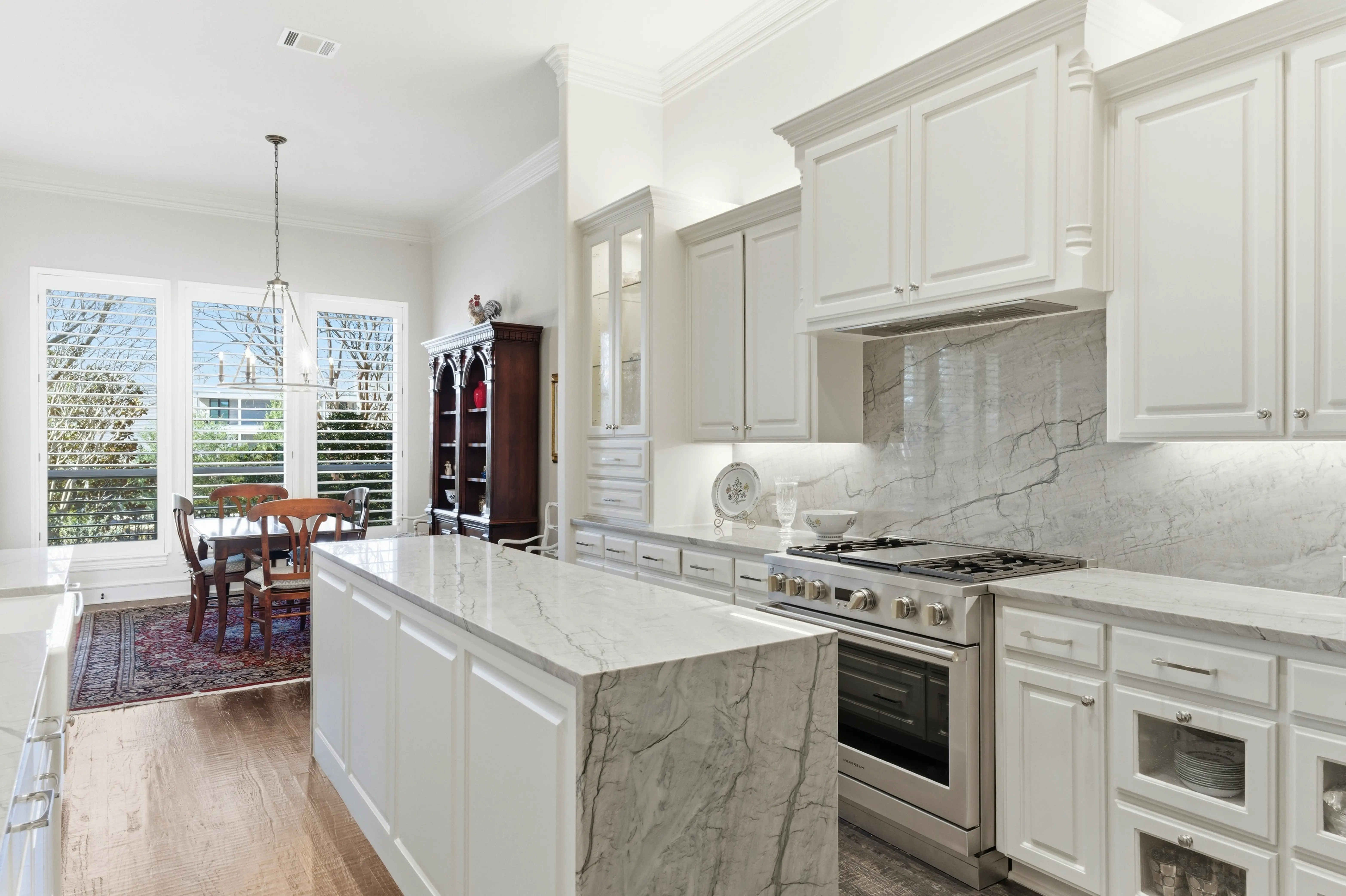 Kitchen view with glass-front upper cabinets and pendant lighting